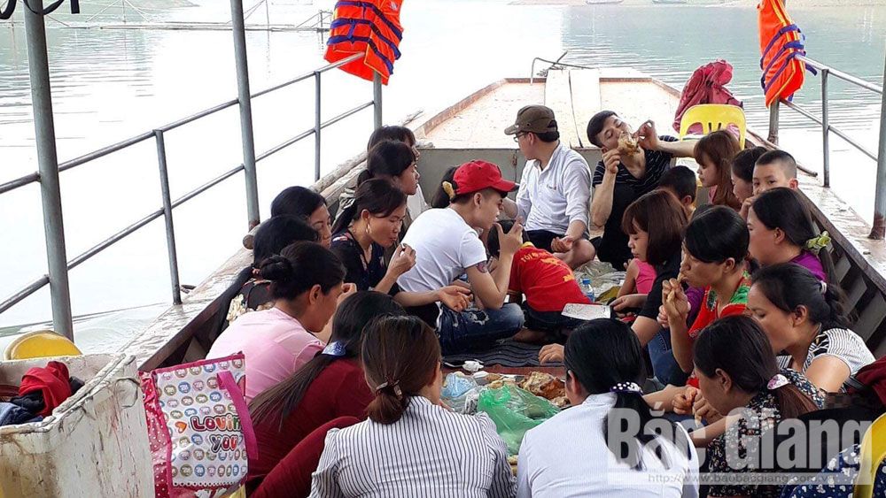 Tourists take a boat to visit Cam Son Lake