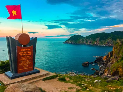 The image of a red flag with a yellow star on Cape Dien