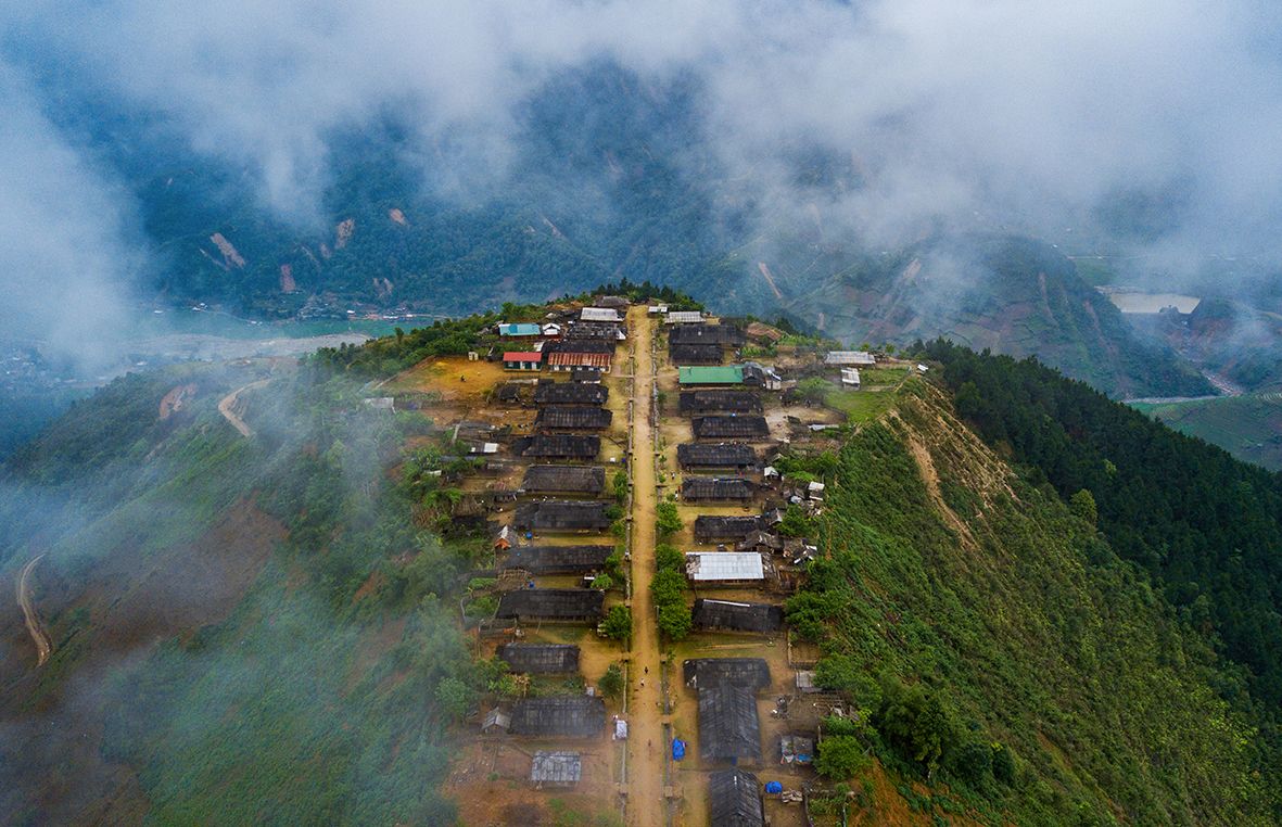 从高空俯瞰，Cu Vai 村在雾气和云彩中显得昏暗